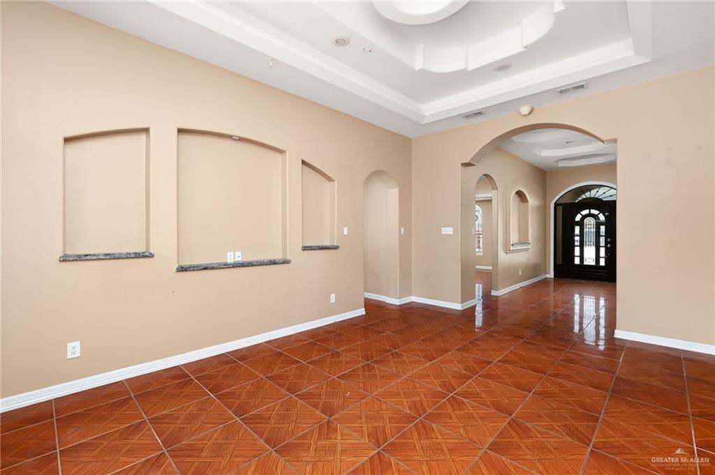 1315 Ruger Street Donna, TX 78537 - Photo 6 of 17 The living space features patterned tile flooring, arched wall niches with dark stone sills, and a tray ceiling