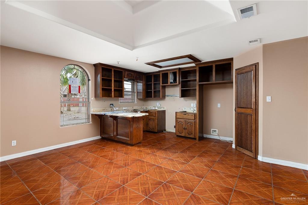 1315 Ruger Street Donna, TX 78537 - Photo 7 of 17 This space features an arched window, wood cabinetry, and a textured tile floor