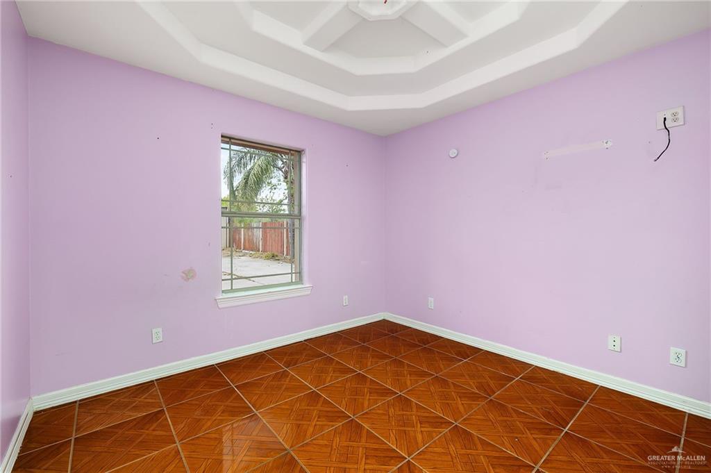 1315 Ruger Street Donna, TX 78537 - Photo 10 of 17 Room featuring a tray ceiling, a window with exterior views, and patterned tile flooring