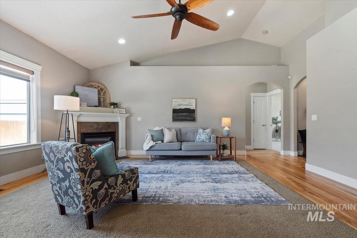 640 Southwest Miner Street Mountain Home, ID 83647 - Photo 27 of 35 Spacious living area featuring a vaulted ceiling with a ceiling fan, recessed lighting, and a fireplace with a white mantel and dark stone surround