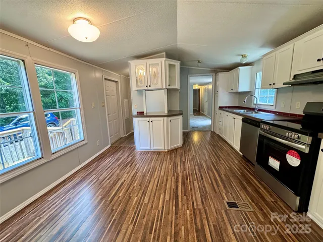 a kitchen with stainless steel appliances wooden floors and wooden cabinets