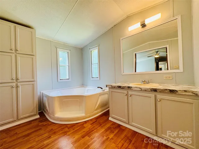 a bathroom with a tub sink and mirror