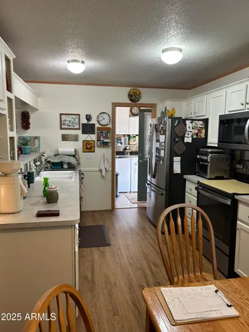 a kitchen with stainless steel appliances wooden floor and a refrigerator