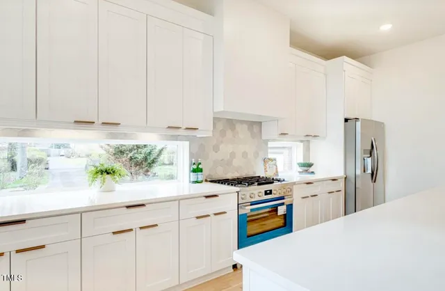 a kitchen with stainless steel appliances white cabinets and a refrigerator