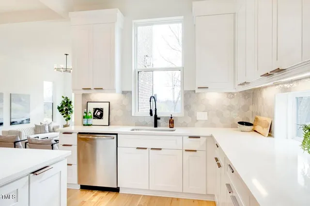 a kitchen with a sink white cabinets and white appliances