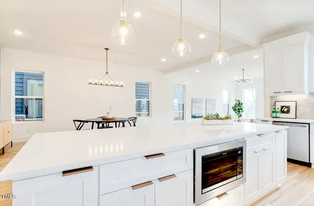 a kitchen with kitchen island a stove a sink a center island and a wooden floor