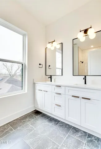 a spacious bathroom with a double vanity sink a mirror and a bathtub