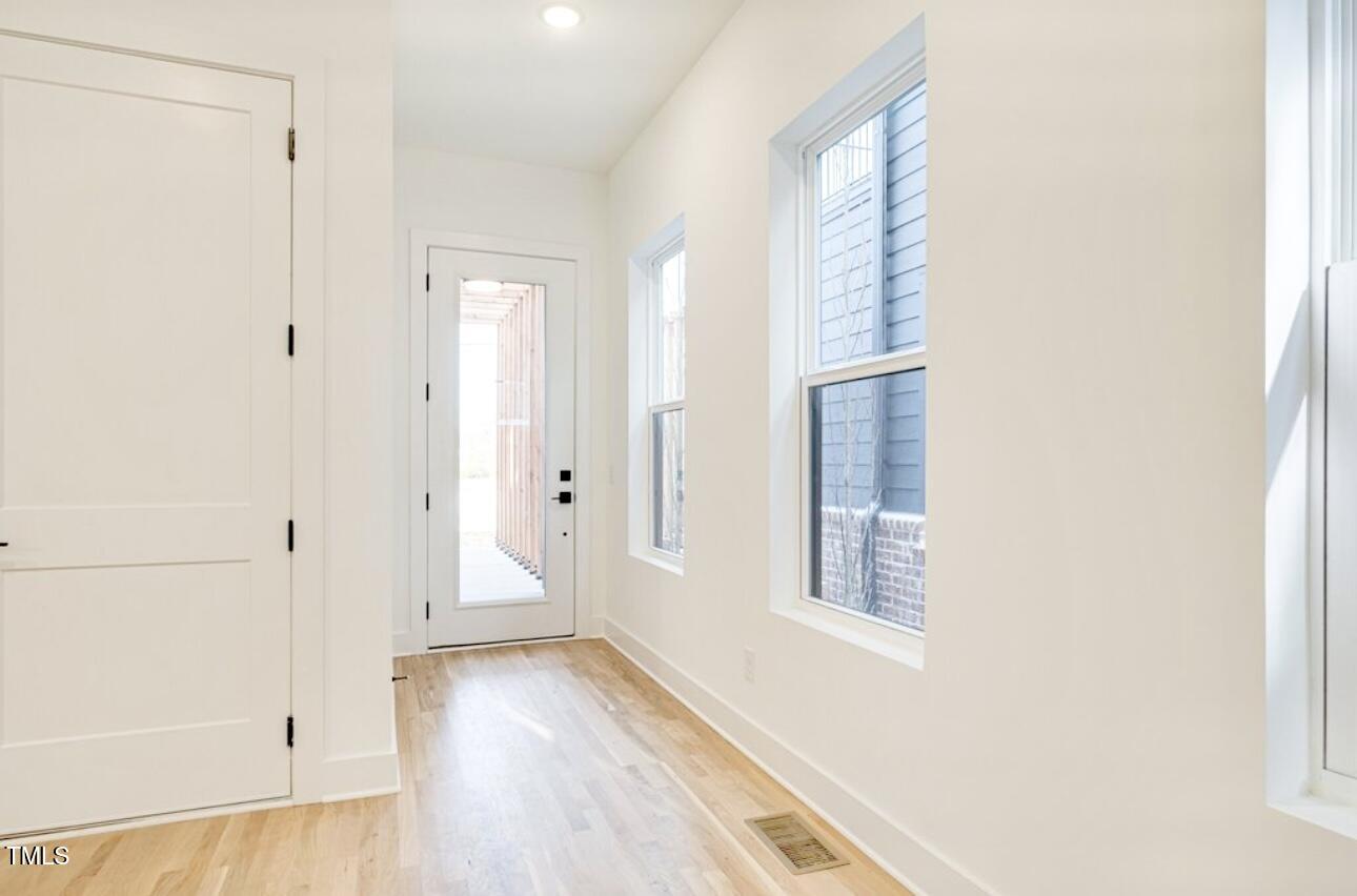 322 South Dixon Avenue, Unit R Cary, NC 27511 - Photo 8 of 37 a view of an empty room with wooden floor and a window