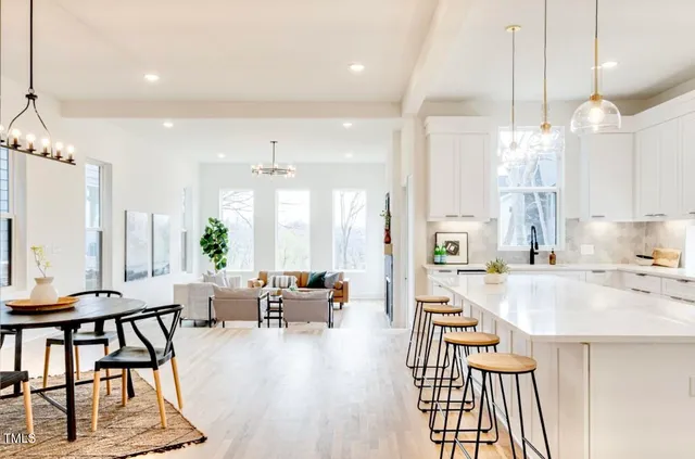 a large kitchen with sink a refrigerator and chairs