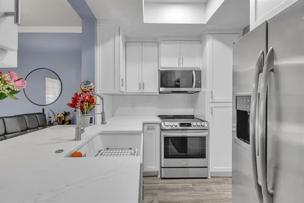 a kitchen with stainless steel appliances granite countertop a refrigerator and a stove top oven