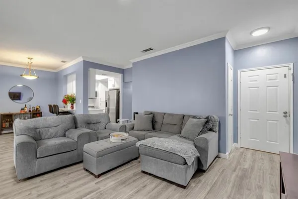 a living room with furniture and a wooden floor