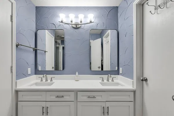 a bathroom with double vanity sinks and a mirror