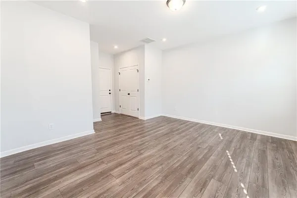 a view of a room with wooden floor and white walls