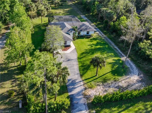 an aerial view of a house with a yard and lake view