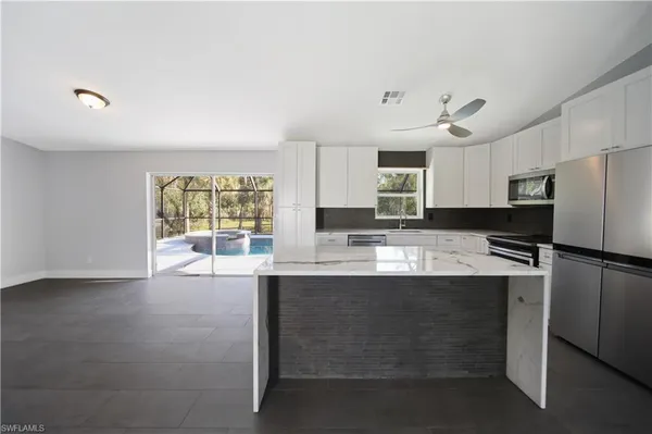 a kitchen with kitchen island a sink stainless steel appliances and window