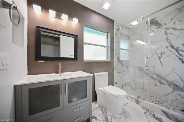 a bathroom with a toilet sink and mirror