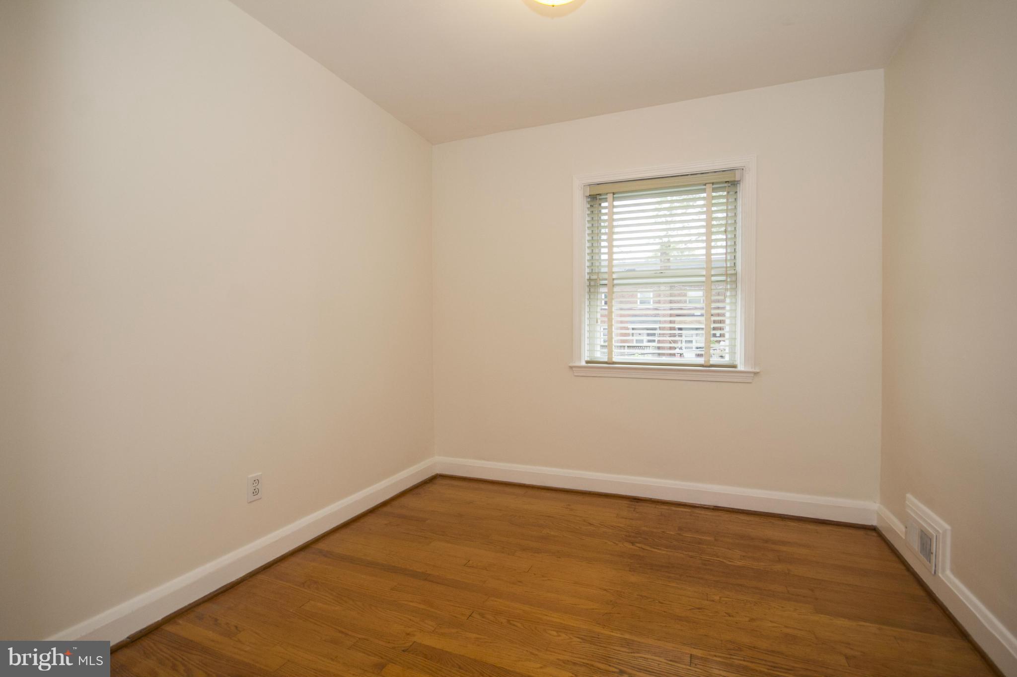 5626 Sagra Road Baltimore, MD 21239 - Photo 14 of 27 wooden floor in an empty room with a window