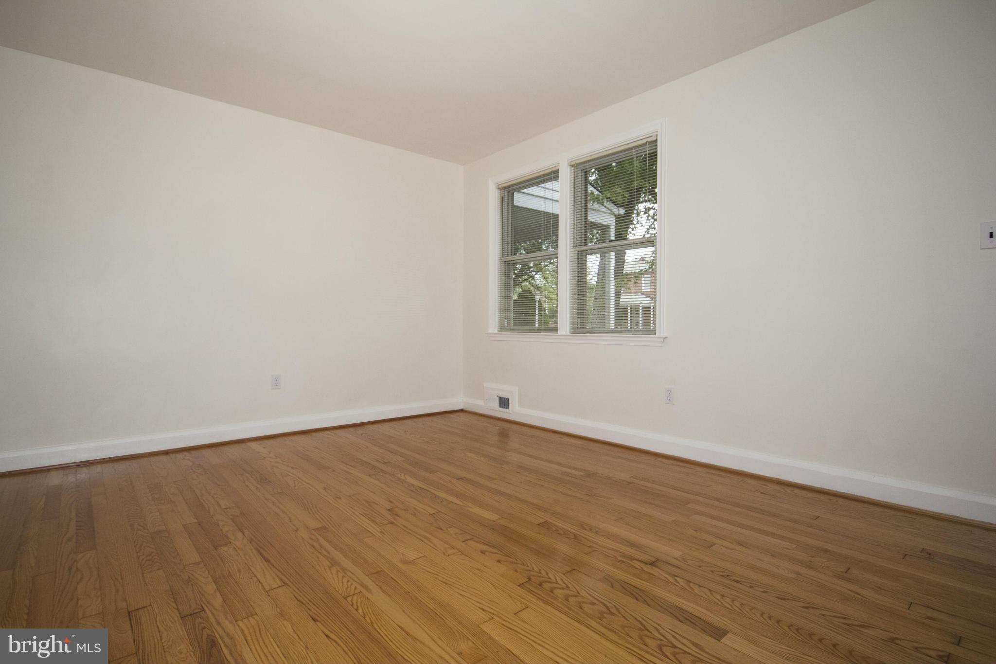 5626 Sagra Road Baltimore, MD 21239 - Photo 3 of 27 an empty room with wooden floor and windows