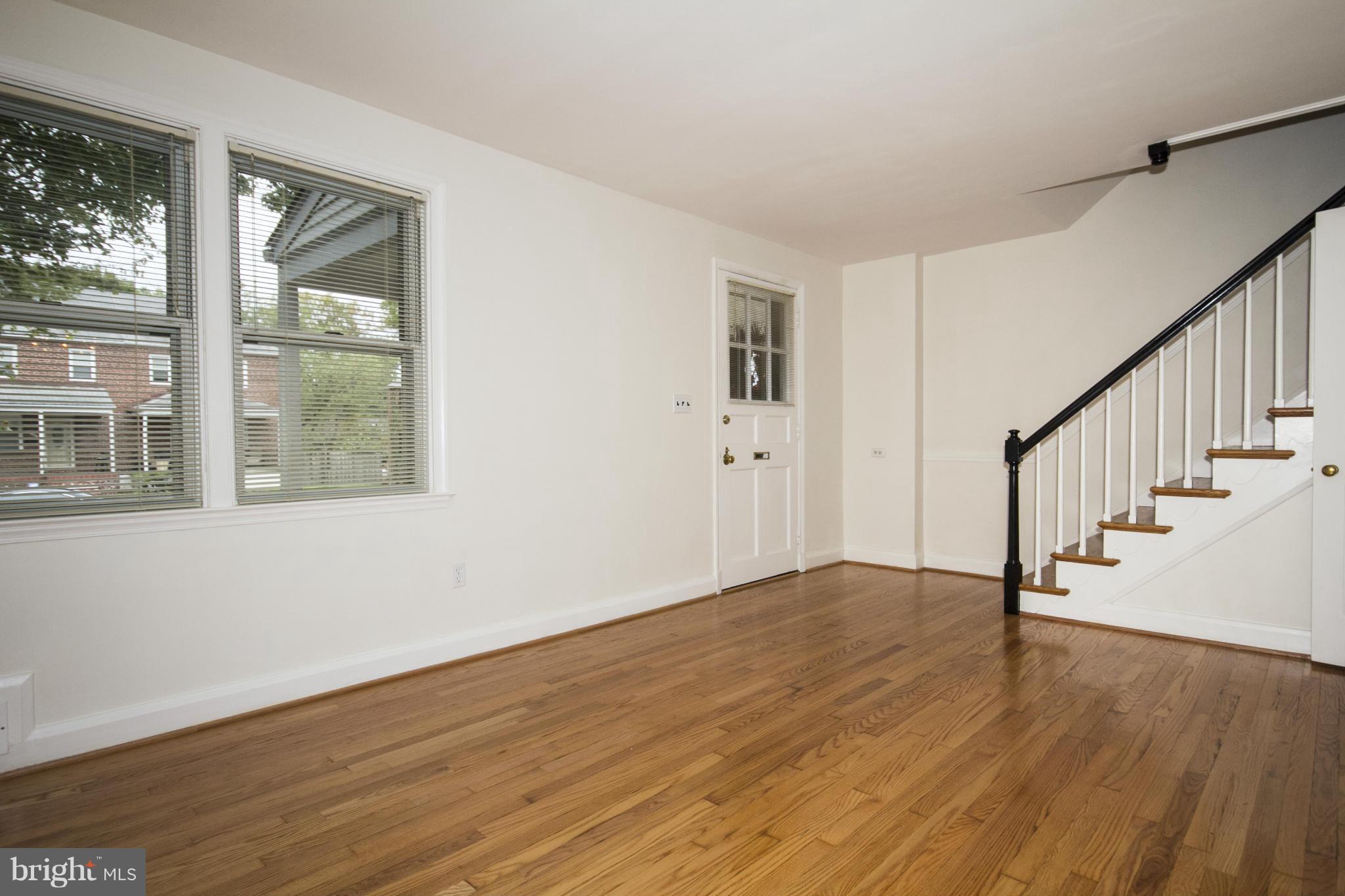 5626 Sagra Road Baltimore, MD 21239 - Photo 4 of 27 a view of an empty room with wooden floor and a window