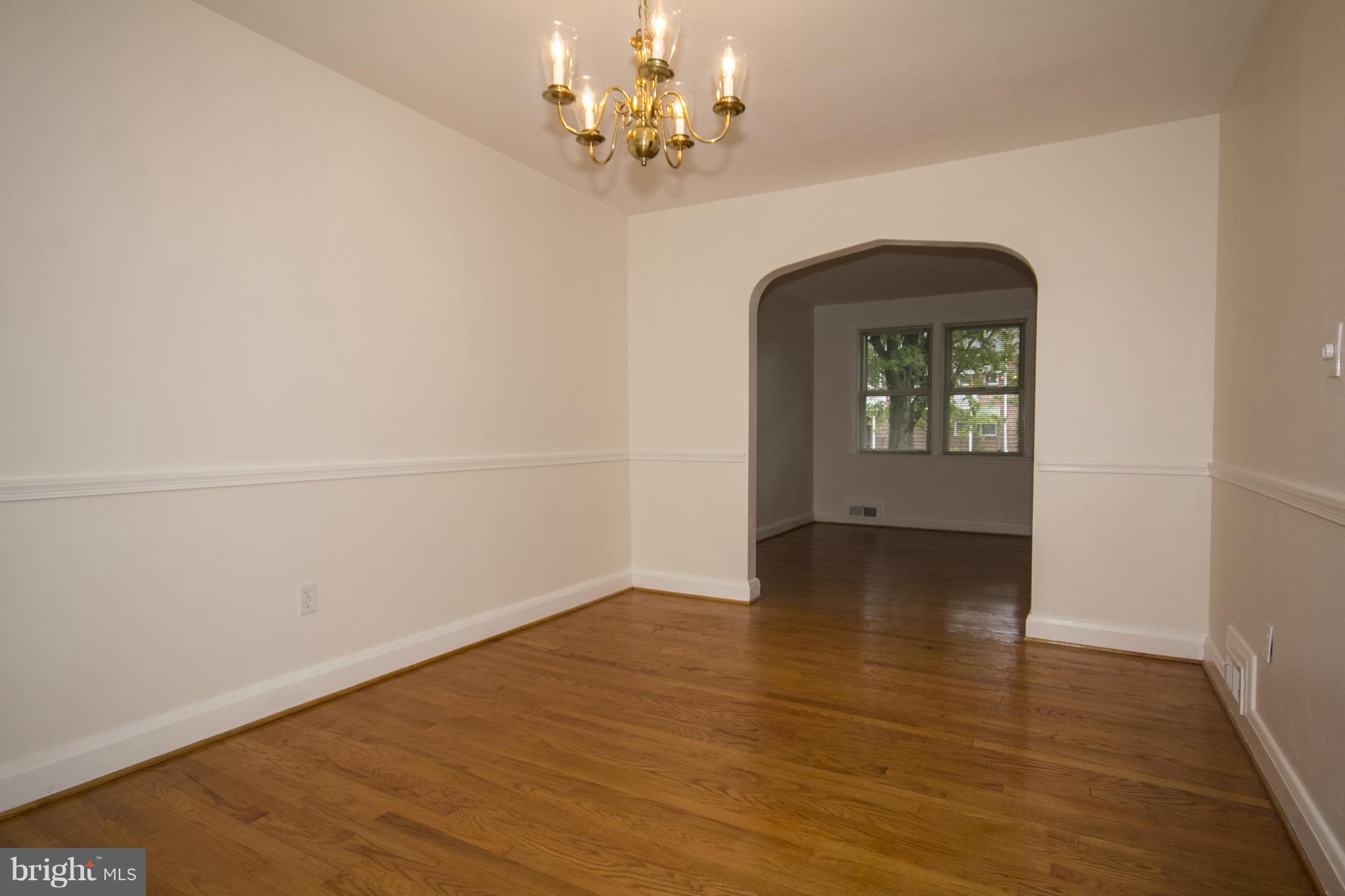 5626 Sagra Road Baltimore, MD 21239 - Photo 7 of 27 a view of a room with wooden floor chandelier and a window