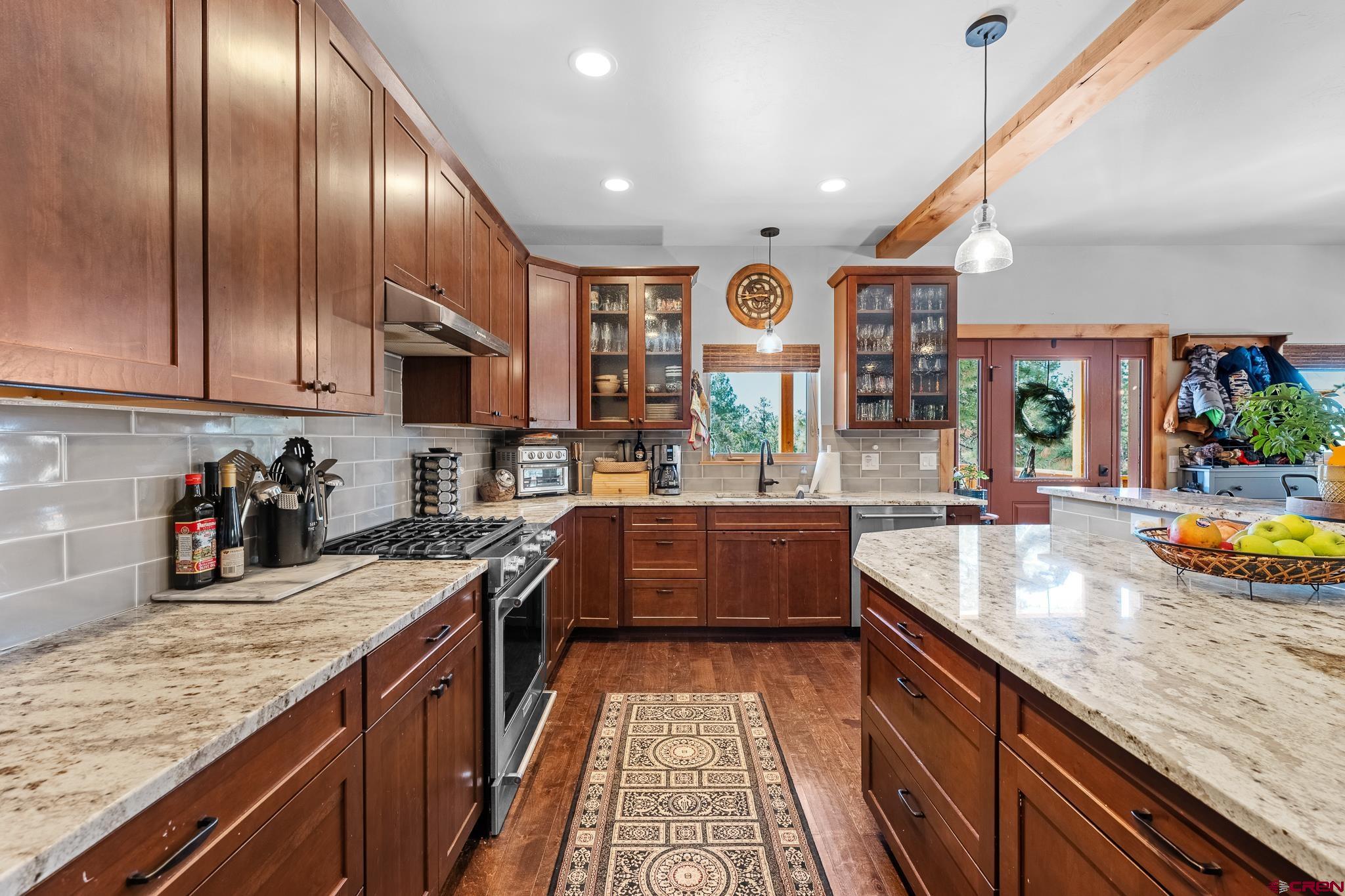 51 West Fork Road Durango, CO 81303 - Photo 6 of 35 a kitchen with stainless steel appliances granite countertop sink stove top oven and cabinets