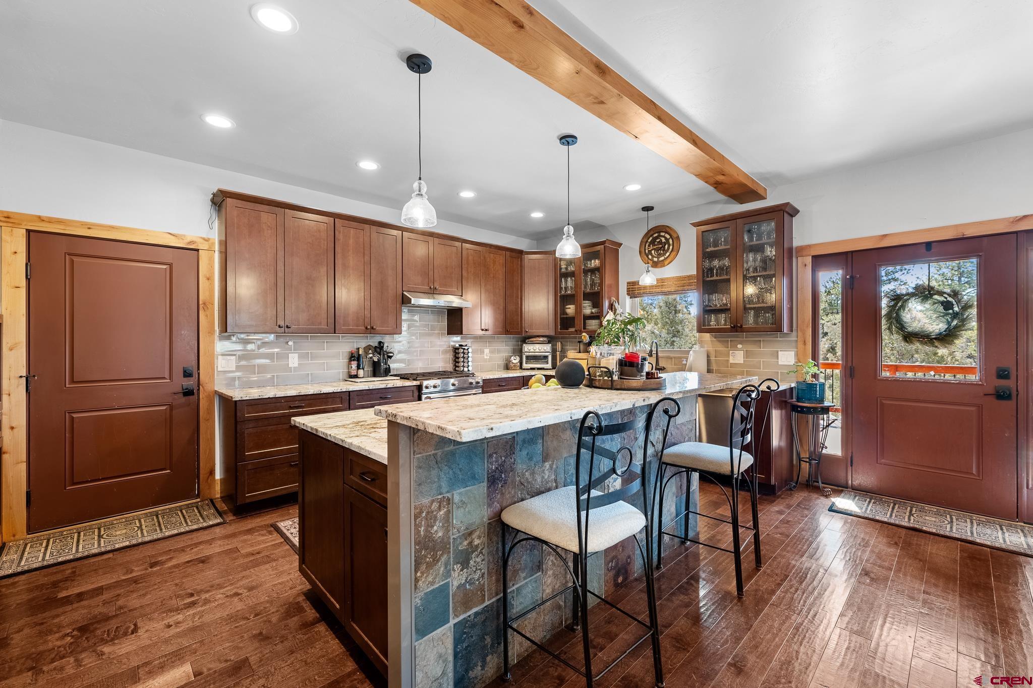 51 West Fork Road Durango, CO 81303 - Photo 9 of 35 a kitchen with stainless steel appliances granite countertop a table chairs sink refrigerator and cabinets