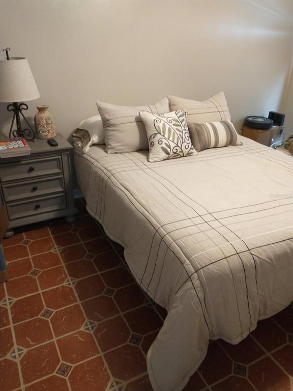 11541 Orleans Lane Port Richey, FL 34668 - Photo 19 of 24 a bedroom with a bed and a lamp on table