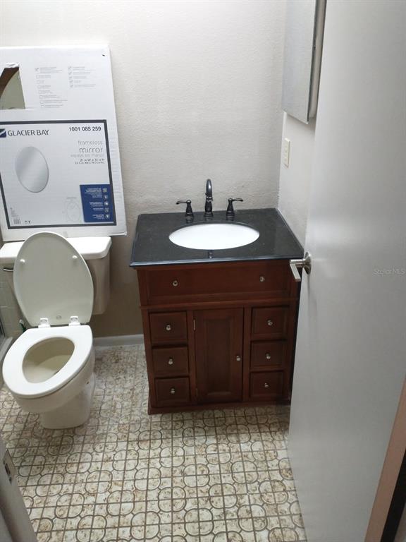 11541 Orleans Lane Port Richey, FL 34668 - Photo 20 of 24 a bathroom with a toilet a sink and mirror