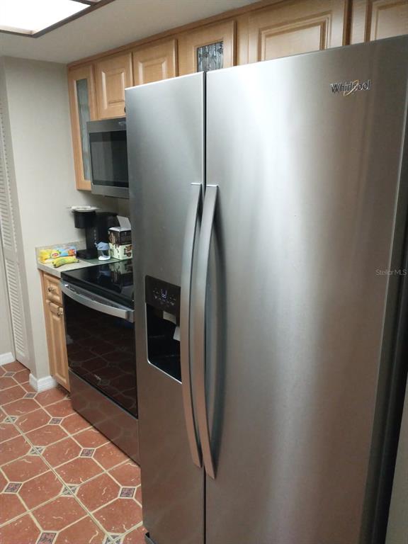 11541 Orleans Lane Port Richey, FL 34668 - Photo 7 of 24 a kitchen with a refrigerator and a stove top oven