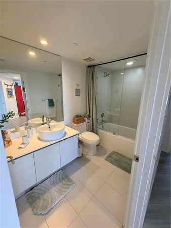 a bathroom with a tub sink and mirror