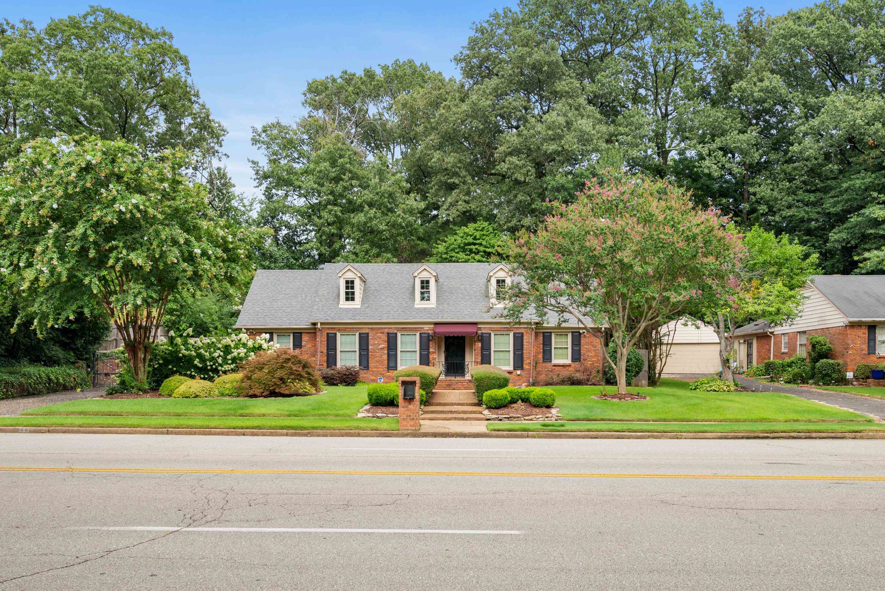 52 North Yates Road Memphis, TN 38120 - Photo 1 of 40 a front view of a house with a garden and trees
