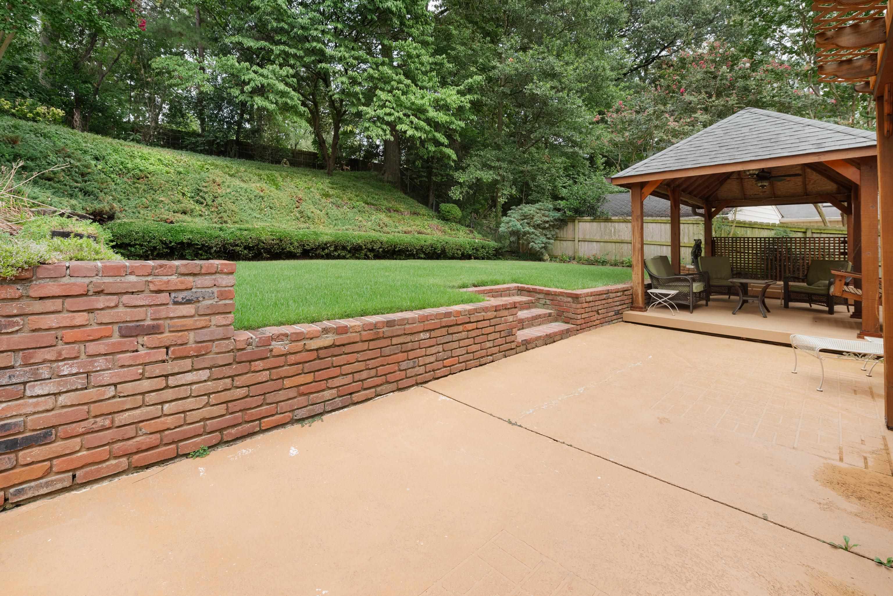 52 North Yates Road Memphis, TN 38120 - Photo 35 of 40 a view of backyard with table and chairs under an umbrella