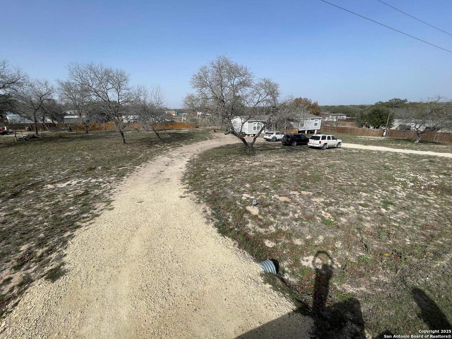 116 Rocky Ridge Drive Poteet, TX 78065 - Photo 3 of 13 a view of dirt road with a building in the background