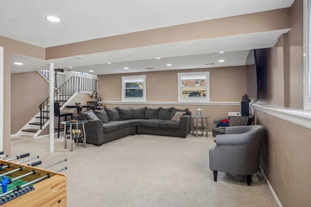 a living room with furniture and a gym machine with wooden floor