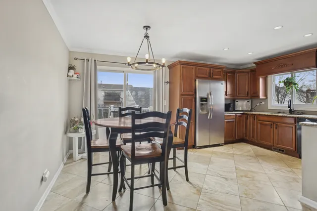 a kitchen with stainless steel appliances a dining table chairs and granite counter tops