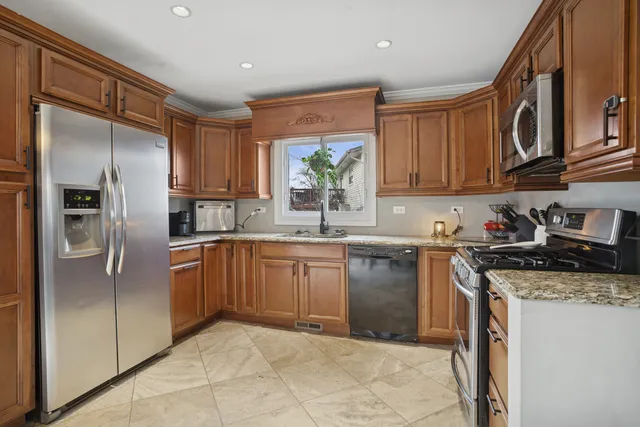 a kitchen with stainless steel appliances granite countertop a refrigerator sink and cabinets