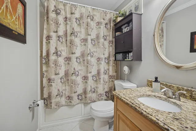 a bathroom with a granite countertop toilet sink and mirror