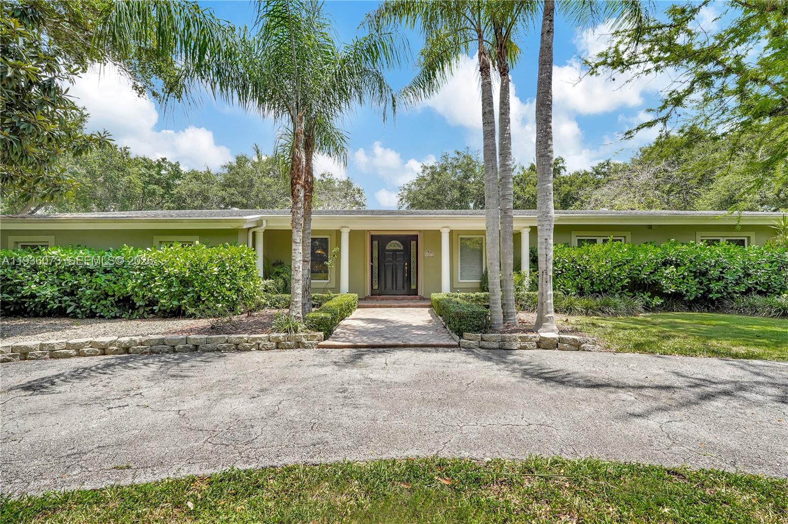 6551 Southwest 126th Street Pinecrest, FL 33156 - Photo 1 of 30 front view of house with a yard and potted plants