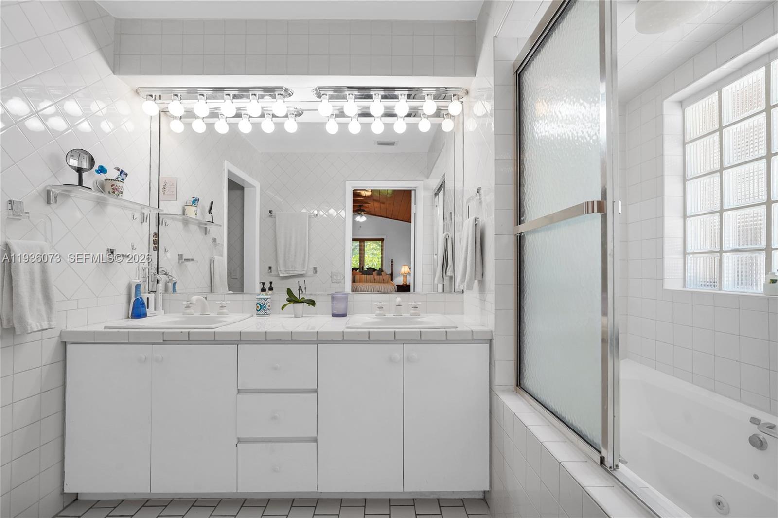 6551 Southwest 126th Street Pinecrest, FL 33156 - Photo 16 of 30 a bathroom with a double vanity sink mirror and bathtub