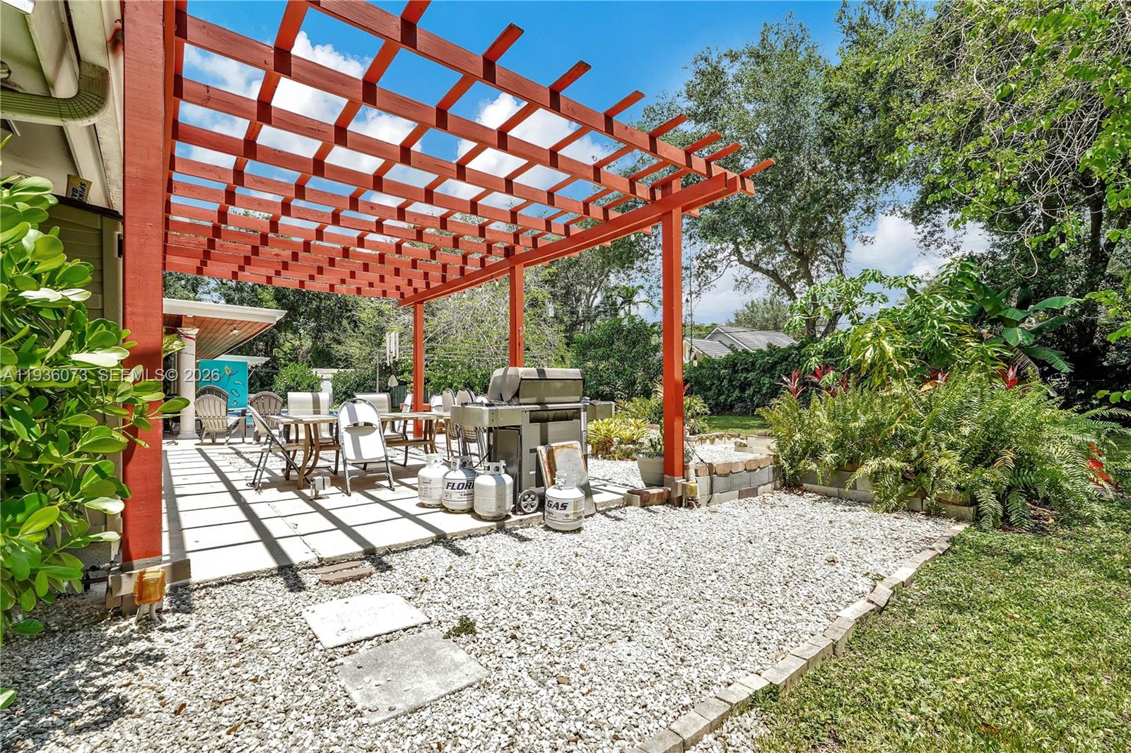 6551 Southwest 126th Street Pinecrest, FL 33156 - Photo 30 of 30 a view of a patio with a table and chairs under an umbrella