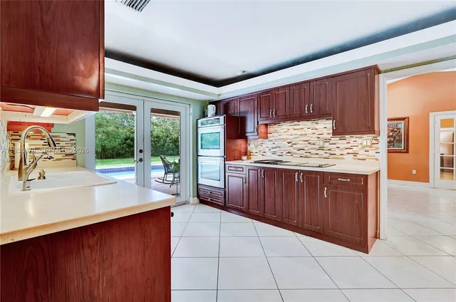 a kitchen with a sink a counter top space and cabinets