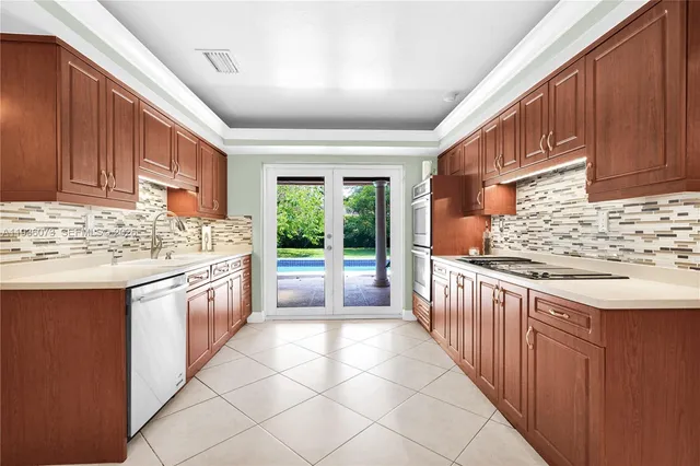 a kitchen with stainless steel appliances granite countertop a stove a sink and a refrigerator