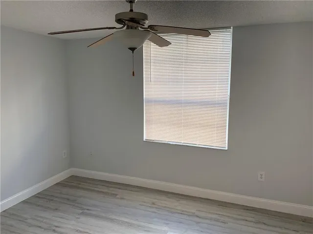 a view of a small space with wooden floor closet and a window