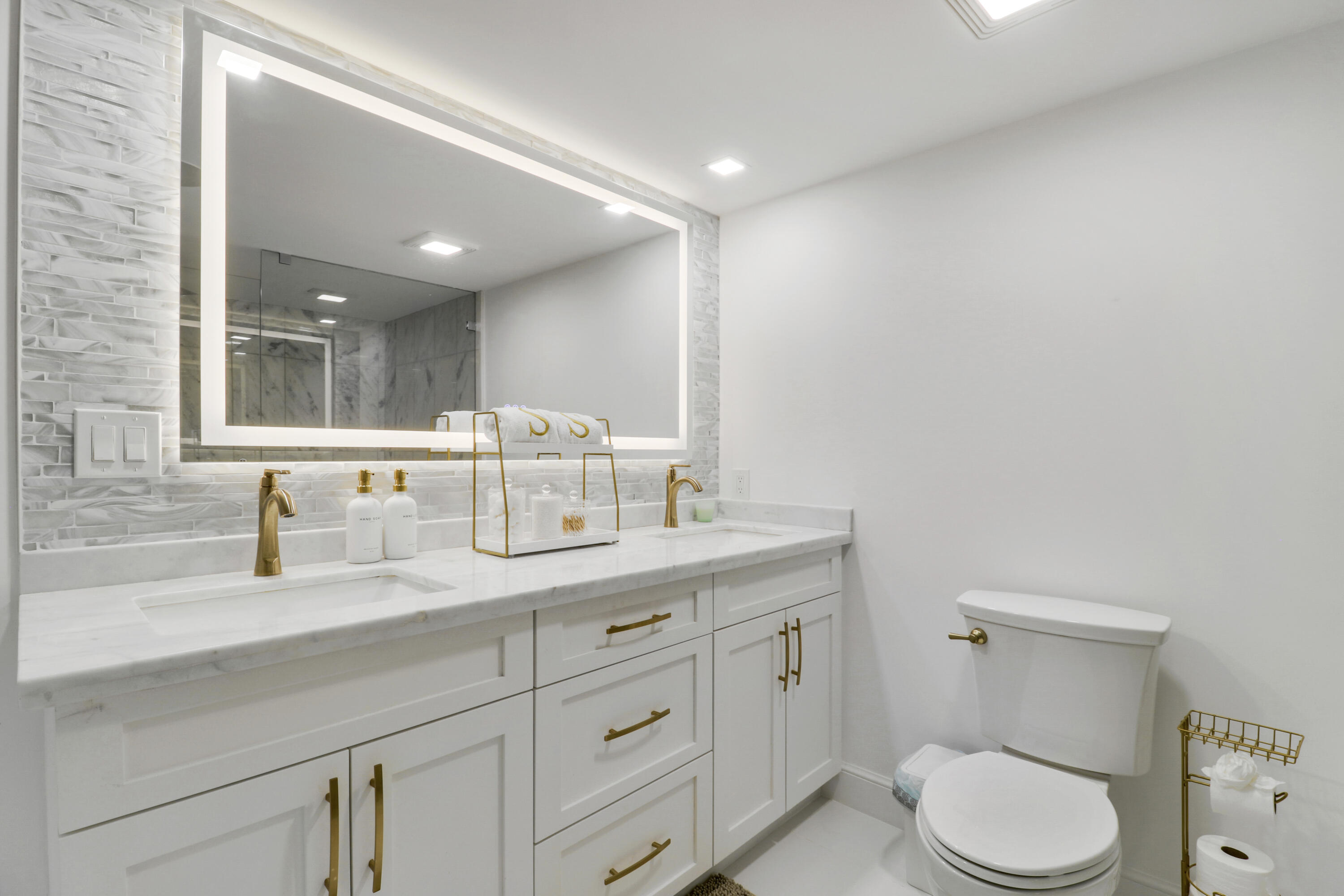 5280 North Ocean Drive, Unit 2F Riviera Beach, FL 33404 - Photo 15 of 35 a bathroom with a granite countertop toilet sink and mirror