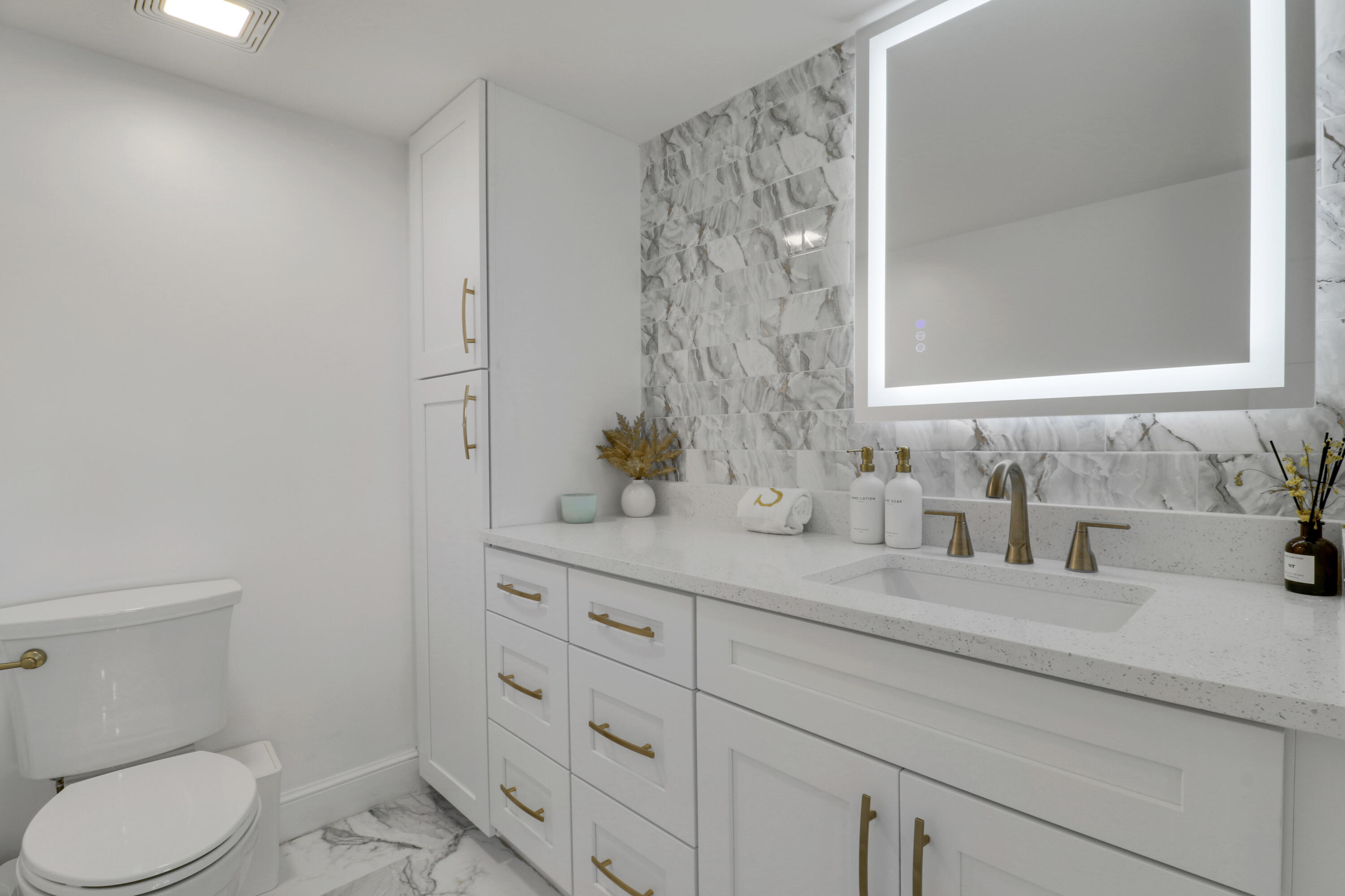 5280 North Ocean Drive, Unit 2F Riviera Beach, FL 33404 - Photo 10 of 35 a bathroom with a granite countertop toilet sink and mirror