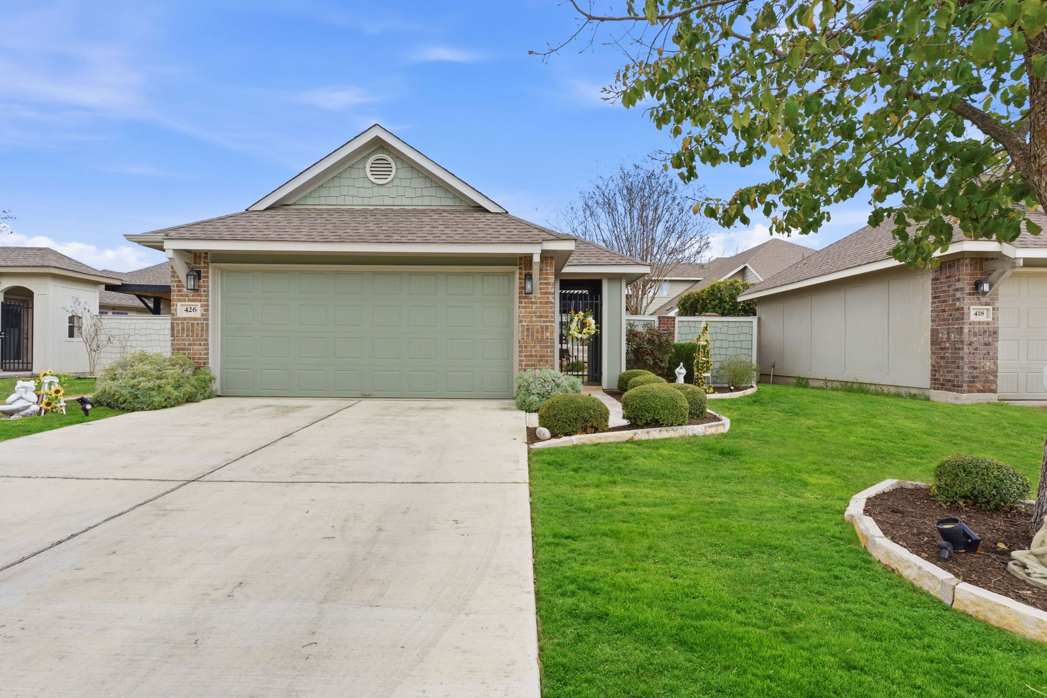 Single story home featuring roof with shingles, a garage, concrete driveway, and brick siding
