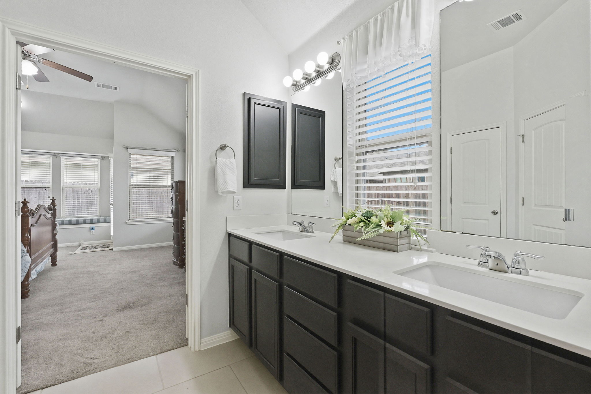 426 Tilly Lane Buda, TX 78610 - Photo 12 of 21 Bathroom with lofted ceiling, light carpet, double vanity, ceiling fan, and light tile patterned flooring