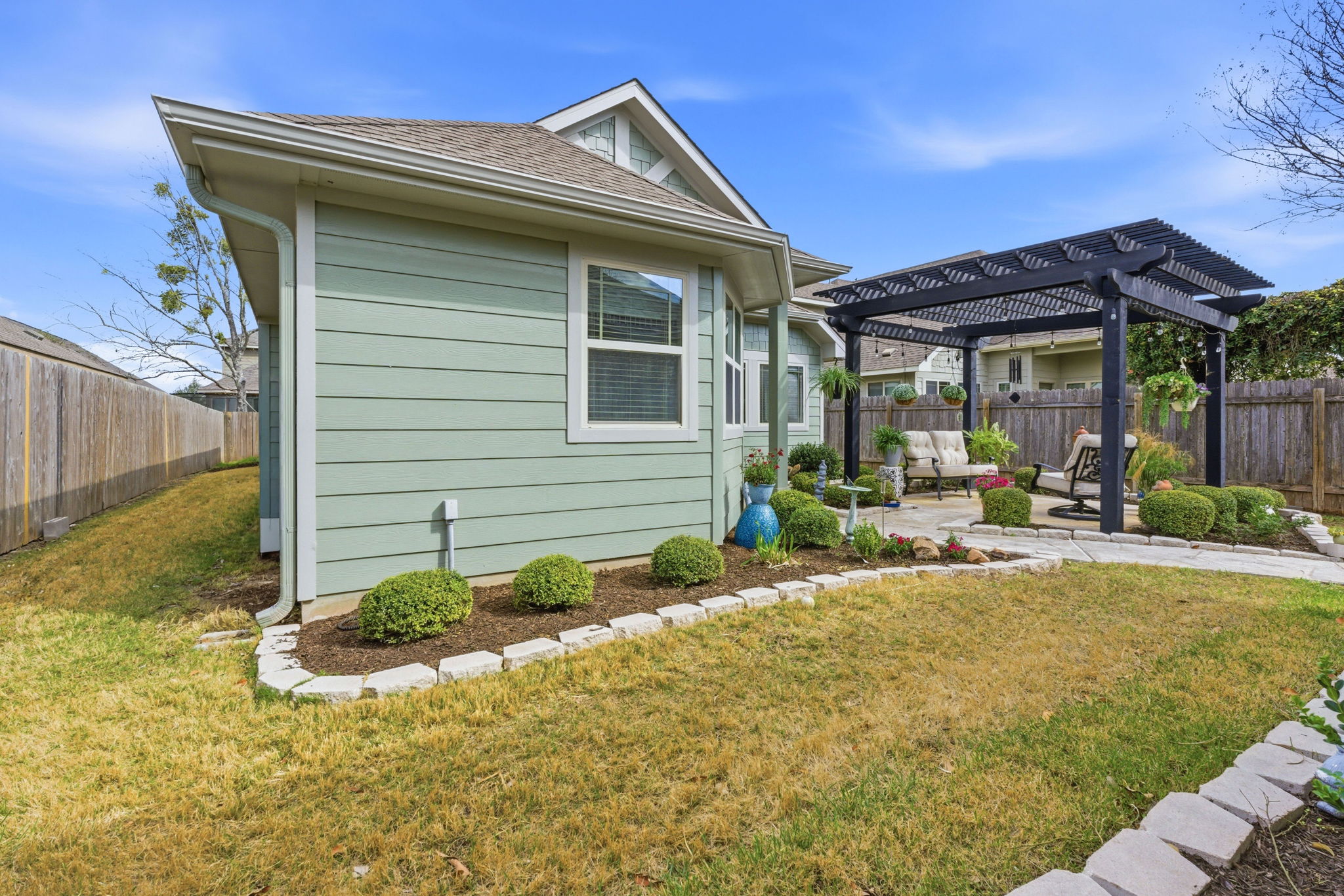 426 Tilly Lane Buda, TX 78610 - Photo 19 of 21 View of home's exterior with a patio area, a pergola, a fenced backyard, and a shingled roof