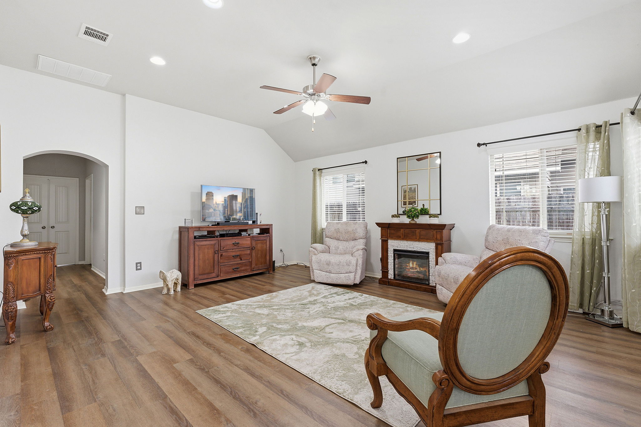 426 Tilly Lane Buda, TX 78610 - Photo 4 of 21 Living room featuring arched walkways, vaulted ceiling, wood finished floors, recessed lighting, and ceiling fan