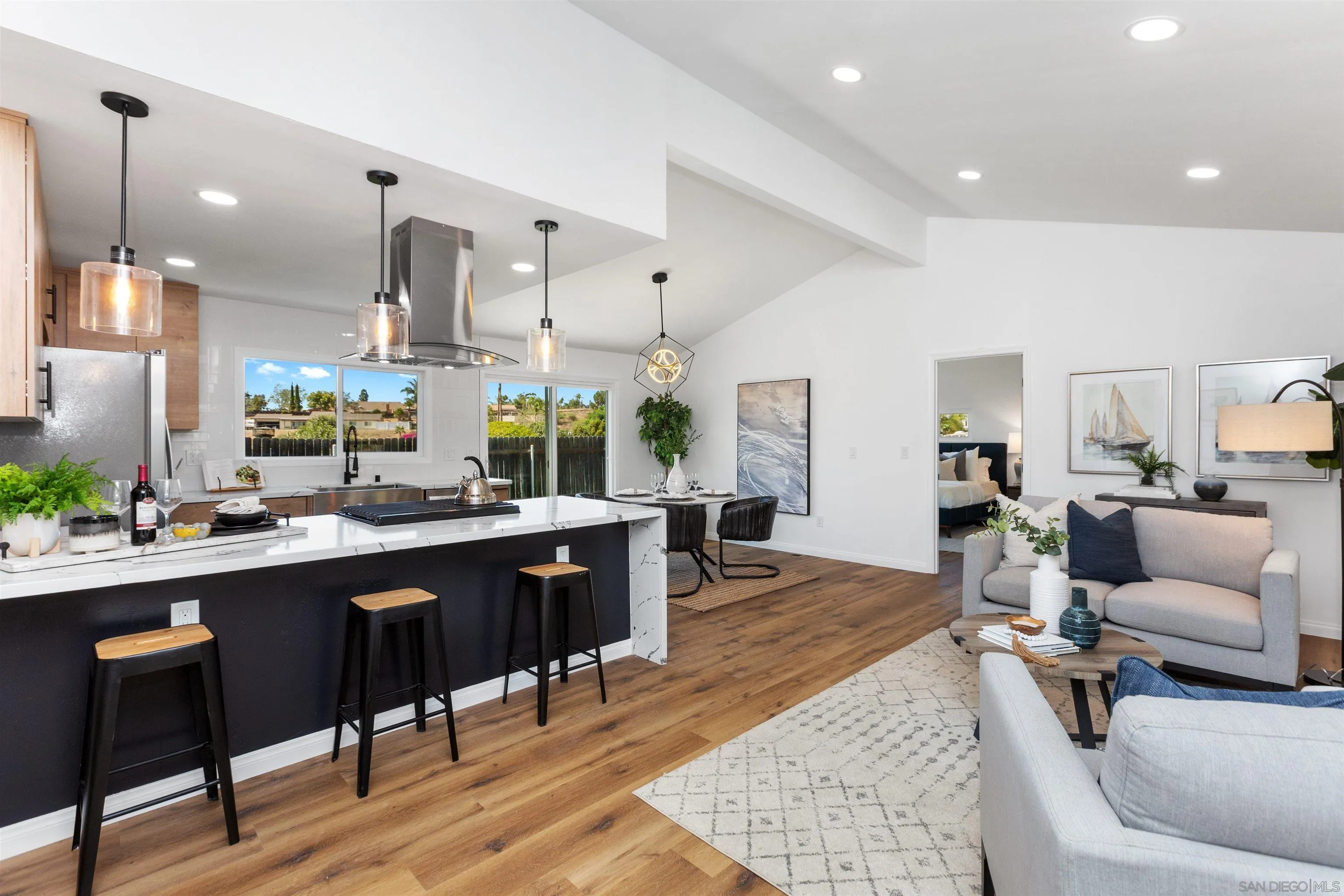 a living room with lots of furniture and view of kitchen
